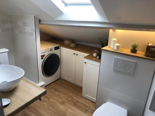 een badkamer met een wasmachine en een wasmachine bij Lucarne Enchantée in Honfleur