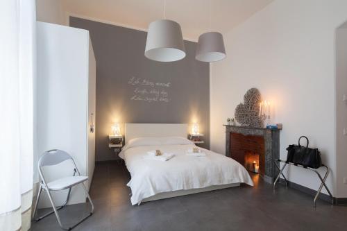 a bedroom with a white bed and a fireplace at AFFITTACAMERE VIA DEI MILLE in La Spezia