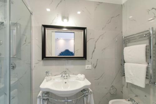 bagno bianco con lavandino e specchio di NLM Boutique Apartment a Roma