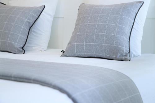a bed with two pillows and a white comforter at Logis Hotel De La Basilique in Albert