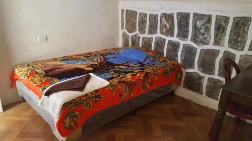 a bed in a room with a painting on the wall at Casa LLEMO in San Pedro La Laguna