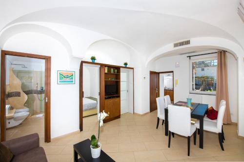 a living room with a table and white chairs at Maison Rosa in Positano