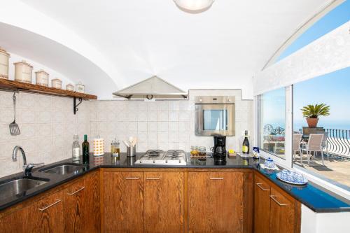 a kitchen with a sink and a counter with a window at Maison Rosa in Positano