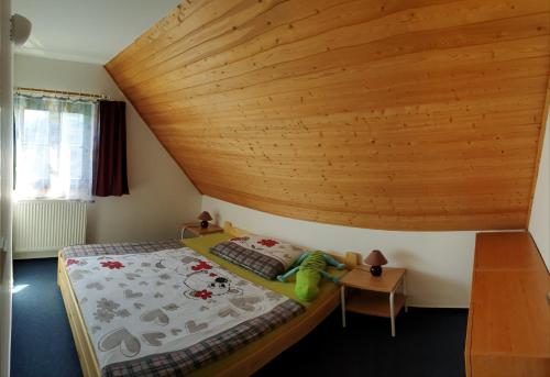 Un dormitorio con una cama con techo de madera. en Happy Chalet, en Černý Důl