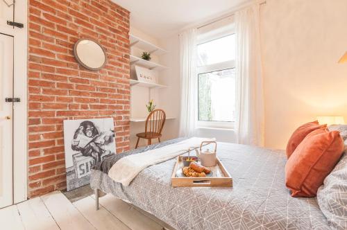 a bedroom with a brick wall and a bed at Regal House Exeter in Exeter