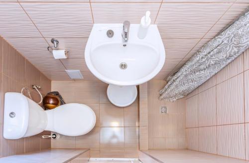 ein Bad mit einem weißen Waschbecken im Zimmer in der Unterkunft Domki Olivia in Władysławowo