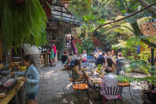 un groupe de personnes assises à des tables dans un jardin dans l'établissement Mesón De Leyendas Breakfast & Downtown, à Valle de Bravo