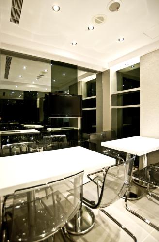 a dining room with white tables and chairs at Saual Keh Hotel in Taipei