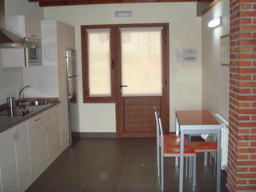 eine kleine Küche mit einem Tisch und einer Tür in der Unterkunft Los Picos de Tereñes in Tereñes
