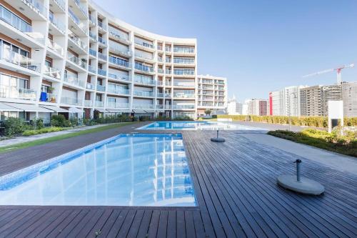 a swimming pool in front of a building at Amazing Flat - Pool and Parking in Lisbon