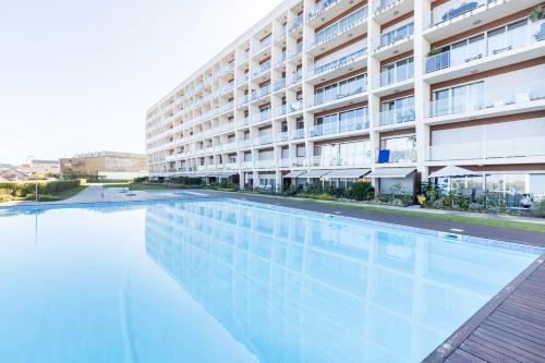 an empty swimming pool in front of a building at Amazing Flat - Pool and Parking in Lisbon