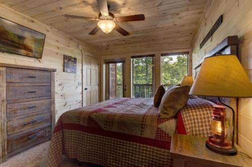 um quarto com uma cama e uma ventoinha de tecto em Sky View Lodge Home em Pigeon Forge
