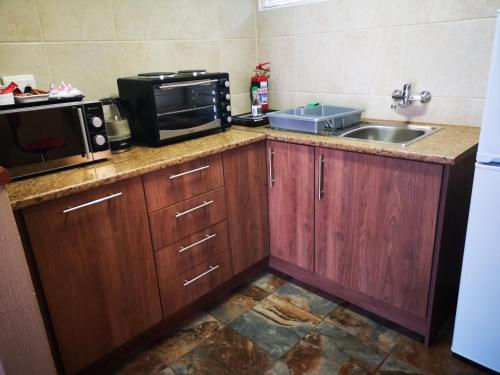 a kitchen with a sink and a microwave at De Oude Herberg in Centurion