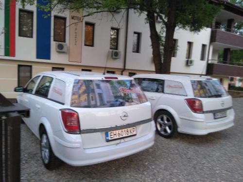two white cars parked in front of a building at Complex Friends in Pleven
