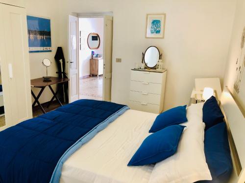 a bedroom with a large bed with blue pillows at Casa Vacanze Sonetto in Maruggio