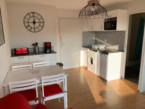 a kitchen with a table and chairs in a room at T2, accès direct plage, proche thalasso in Cabourg