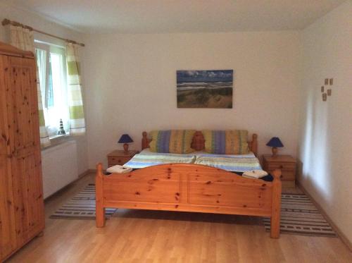 ein Schlafzimmer mit einem Holzbett und einem Sofa in der Unterkunft FeWo Wende in Heringsdorf