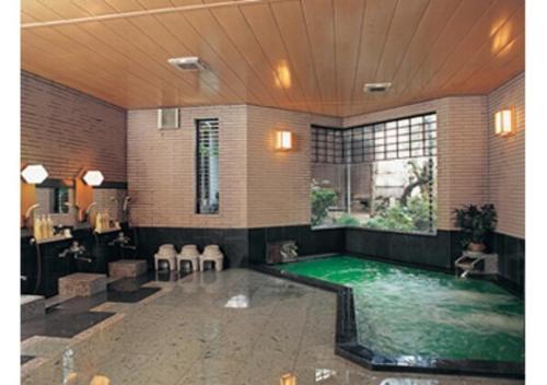 a swimming pool in a room with a large window at Wakaba Ryokan / Vacation STAY 29372 in Sakata