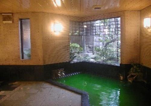 uma piscina de água verde num quarto com janela em Wakaba Ryokan / Vacation STAY 29366 em Sakata