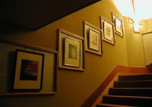 a stairway with framed pictures on a wall at Wakaba Ryokan / Vacation STAY 29376 in Sakata