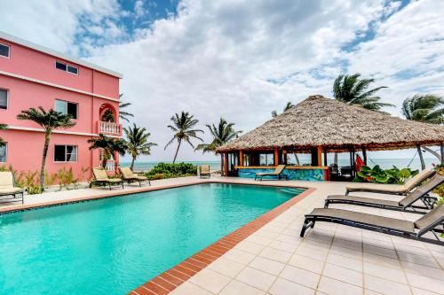 a swimming pool in front of a pink building at Seaview - Caribe Island in San Pedro