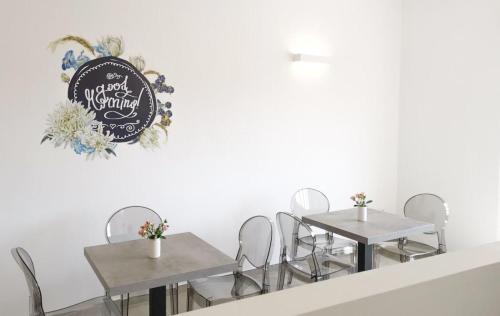two tables and chairs with a sign on the wall at SuitesGaribaldi in Cagliari