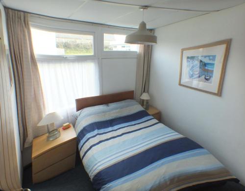1 dormitorio con cama y ventana en Chalet Cwtch en Roch