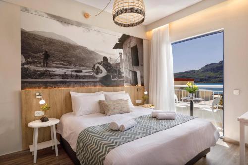 a bedroom with a bed and a large window at Sofia Hotel in Plakias