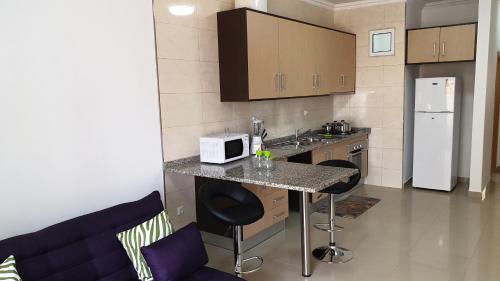 a kitchen with a counter with a microwave and a refrigerator at Appartement de Revé in Praia