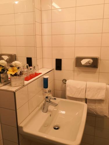 a white bathroom with a sink and a mirror at Hotel Haus vom Guten Hirten in Münster