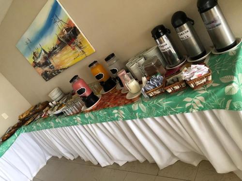Una mesa con un mantel encima con bebidas y café. en Marupiara Suites Flats, en Porto de Galinhas
