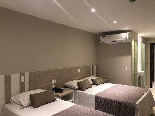 a hotel room with two beds and a heater at Jandira Premiêr Hotel in Jandira