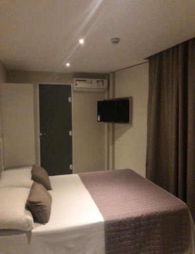 a bedroom with a bed and a television in it at Jandira Premiêr Hotel in Jandira