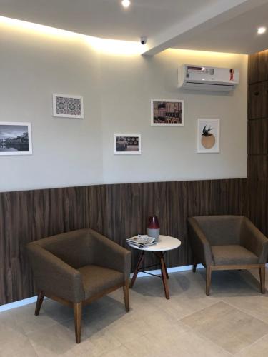 a waiting room with two chairs and a table at Jandira Premiêr Hotel in Jandira