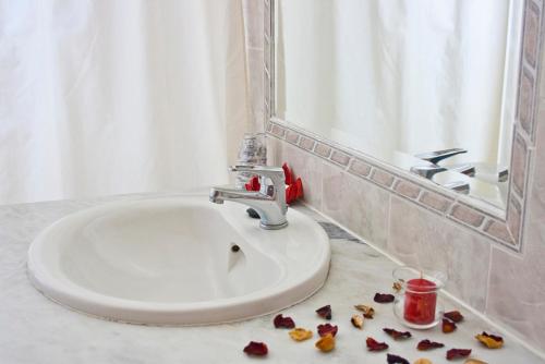 baño con lavabo y pétalos en el suelo en Alte Hotel, en Alte