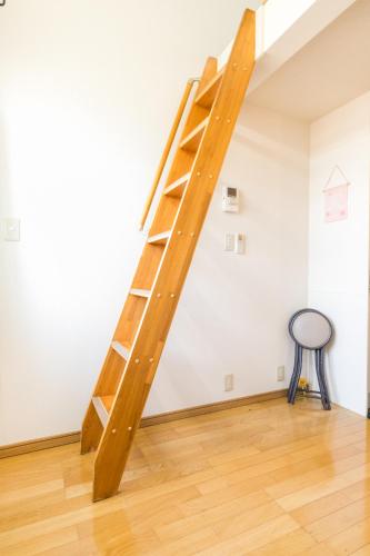 a ladder in the corner of a room with a table at Haneda Airport Apartment in Tokyo