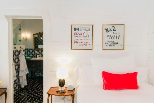 a bedroom with a white bed with a red pillow at The Frenchie in Round Top