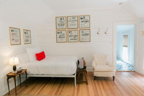 a bedroom with a bed with a red pillow and a chair at The Frenchie in Round Top