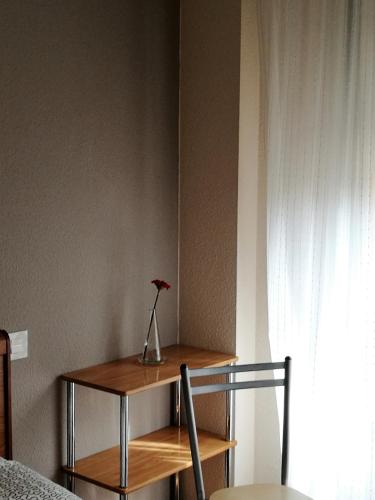 a flower in a vase on a table in a room at Pension Santiago in Burgos