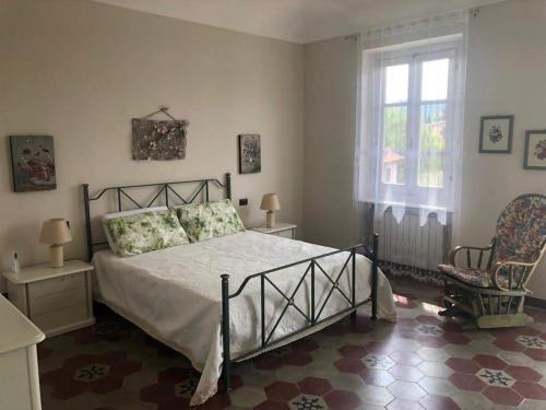 1 dormitorio con cama, ventana y silla en Casa Virginia / Virginia's Home in Turin - Casalborgone, en Casalborgone
