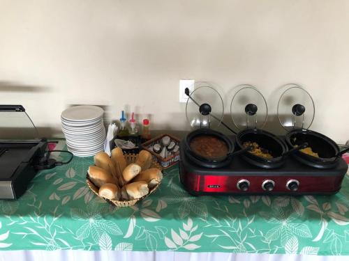 Una mesa con una estufa con comida y un tazón de pan. en Marupiara Suites Flats, en Porto de Galinhas