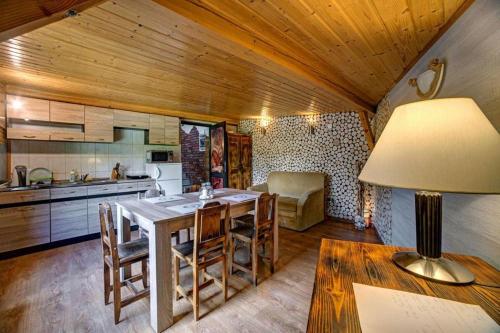 a kitchen with a table with chairs and a lamp at Pensjonat Reda in Polańczyk