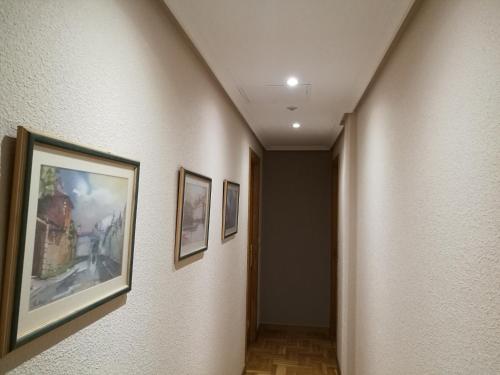 a hallway with two framed pictures on the walls at Pension Santiago in Burgos