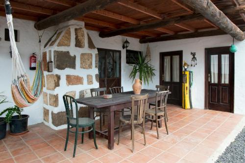Una mesa y sillas de madera en un patio. en La Cuesta14, en Güime
