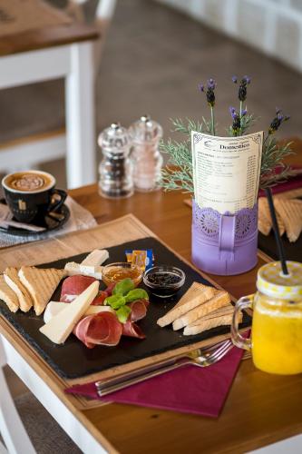 un tavolo con un piatto di carne e formaggio di Sky Apartments a Čilipi