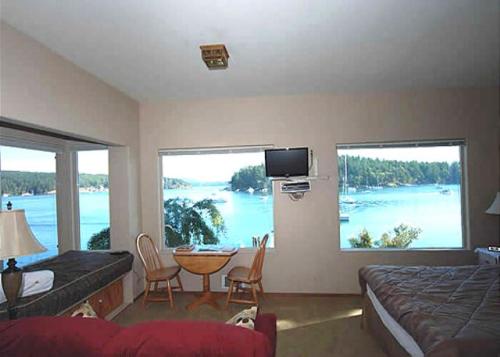 a bedroom with a bed and a table with a view of the water at Sweet Escape & Summer Dream in Friday Harbor