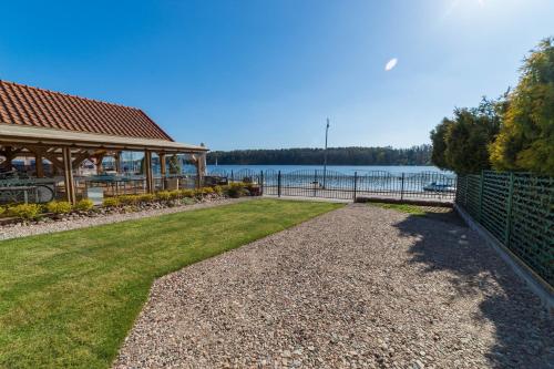 une passerelle menant à un pavillon à côté de l'eau dans l'établissement Promenada Apartamenty i Domek Nad Jeziorem, à Mikołajki