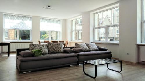 a living room with a couch and some windows at Winzerhaus Loreley in Sankt Goarshausen