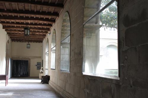 an empty hallway of a building with windows at Hospedería San Martín Pinario in Santiago de Compostela