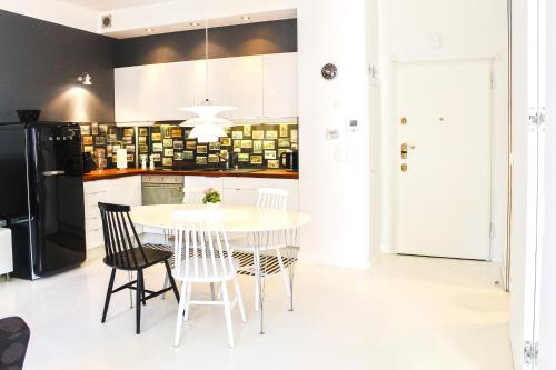 uma cozinha com uma mesa branca e cadeiras em Apartament Relax Neptun Park em Gdansk